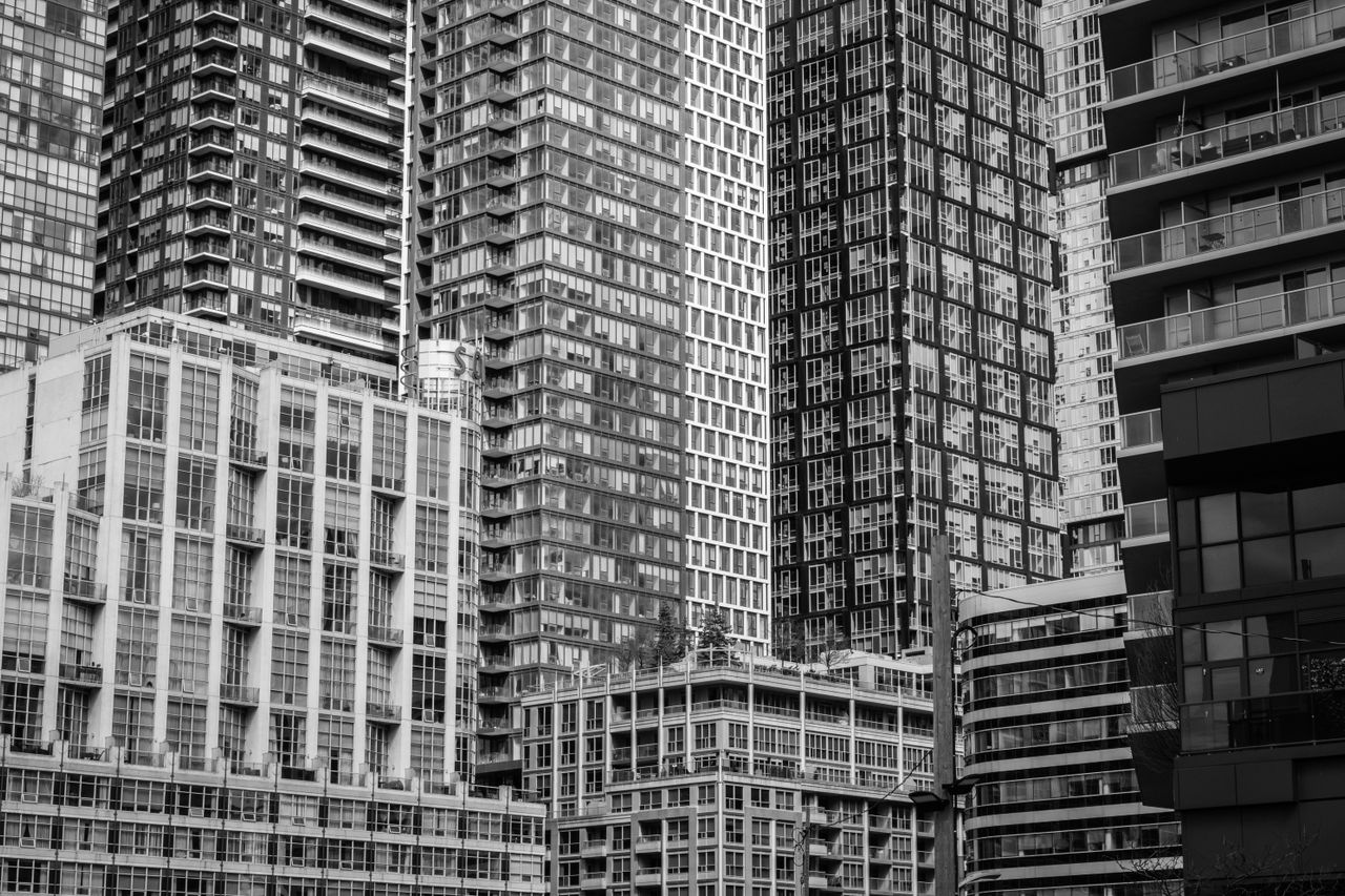 Black and white photo of modern skyscrapers in an urban cityscape.