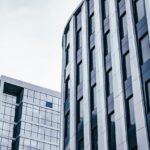 Contemporary office buildings with glass facades under a cloudy sky, showcasing modern urban architecture