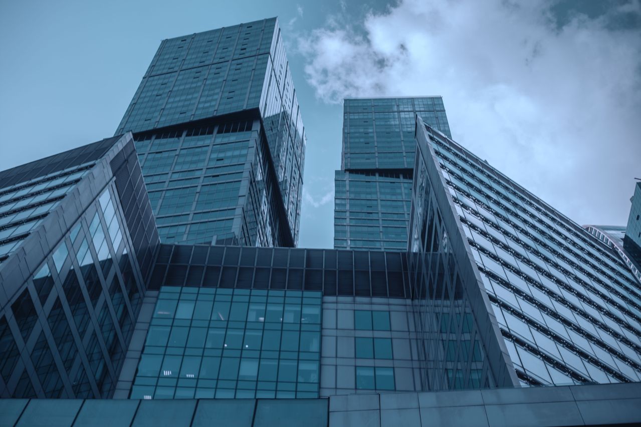 Low angle view of glass skyscrapers reaching into the blue sky, showcasing modern architecture